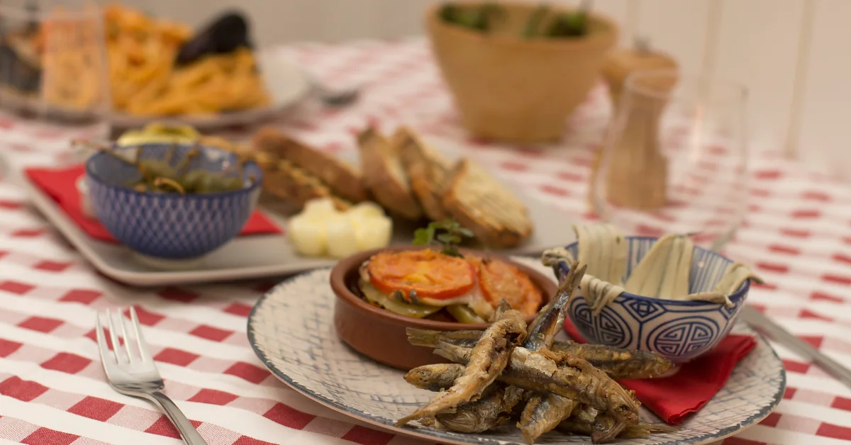 red and white tablecloth with rustic spanish dishes